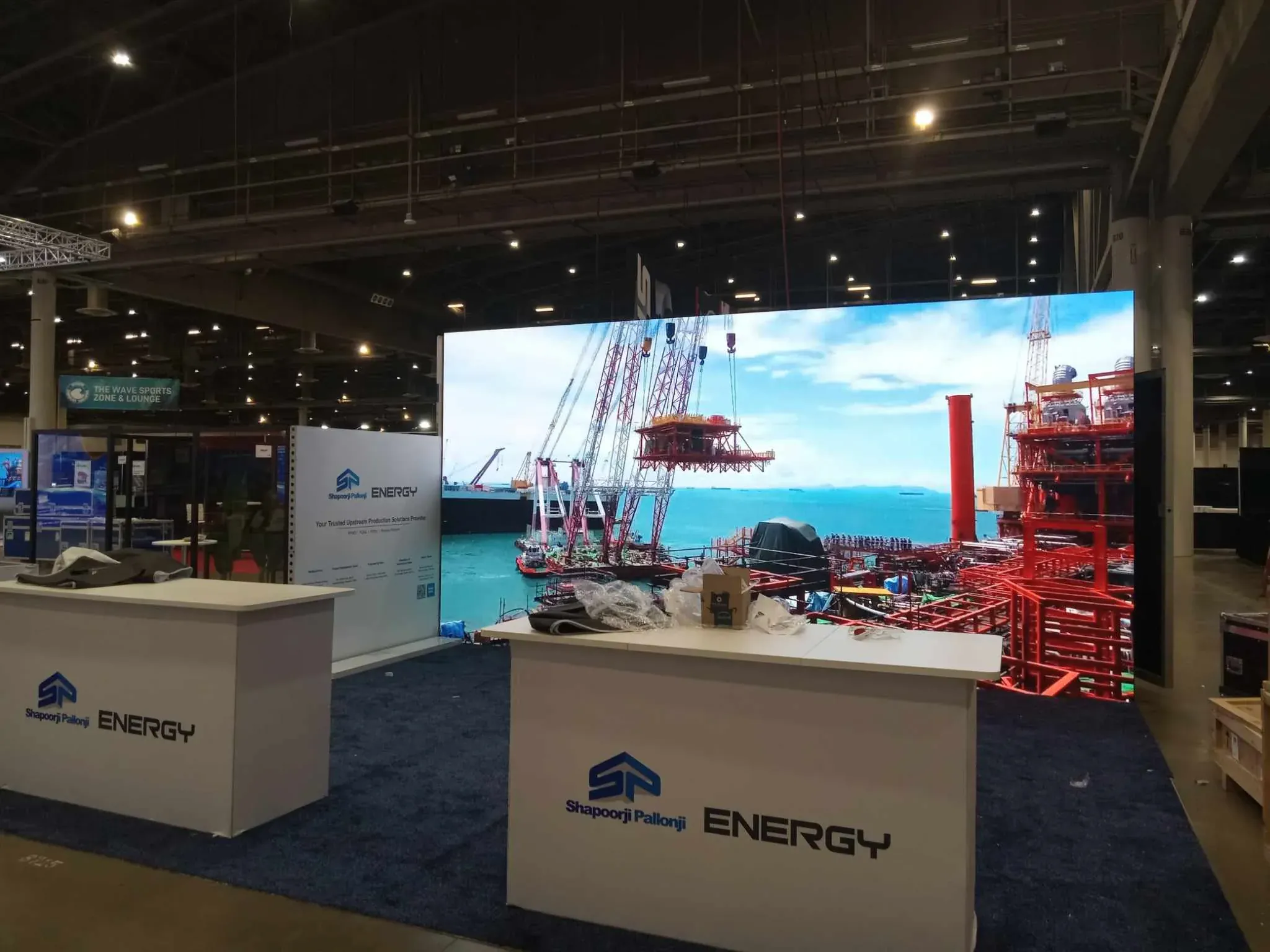 Large LED wall installation at a corporate convention booth showing industrial visuals