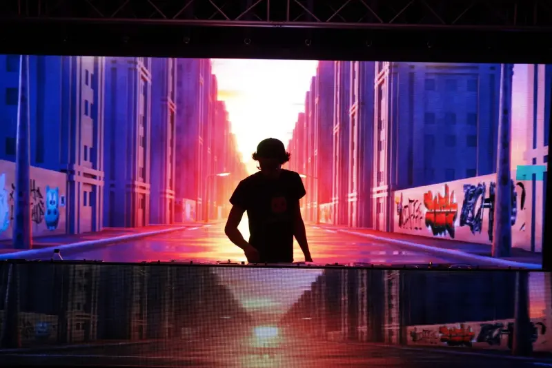 DJ performing with LED wall displaying animated cityscape visuals at a Scranton event